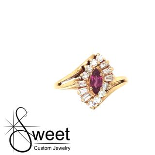 ONE 14KT YELLOW GOLD RUBY AND DIAMOND RING FEATURING A MARQUISE RUBY AND .37CTTW OF ROUND AND BAGUETTE DIAMONDS