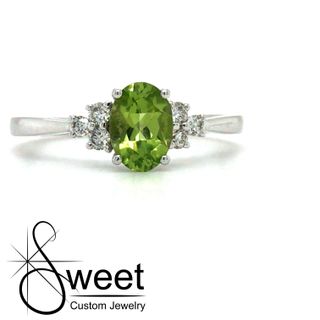 14KT WHITE GOLD RING FEATURING ONE OVAL SHAPED GENUINE PERIDOT ACCENTED BY 3 ROUND BRILLIANT CUT DIAMONDS .15CTTW
