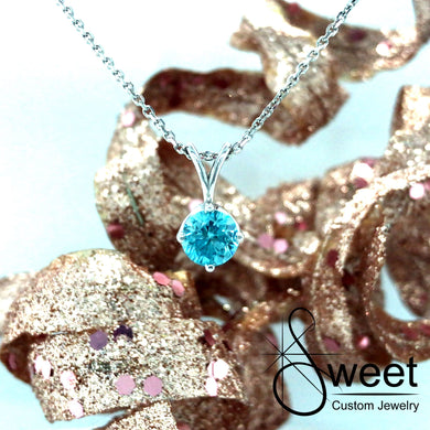 14KT WHITE GOLD PENDANT FEATURING ONE ROUND BLUE ZIRCON.